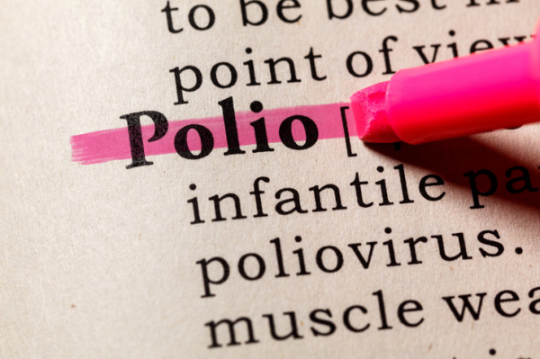 The tip of a pink highlighter pen running over the word "Polio;" a few words from a definition of the illness are also shown 